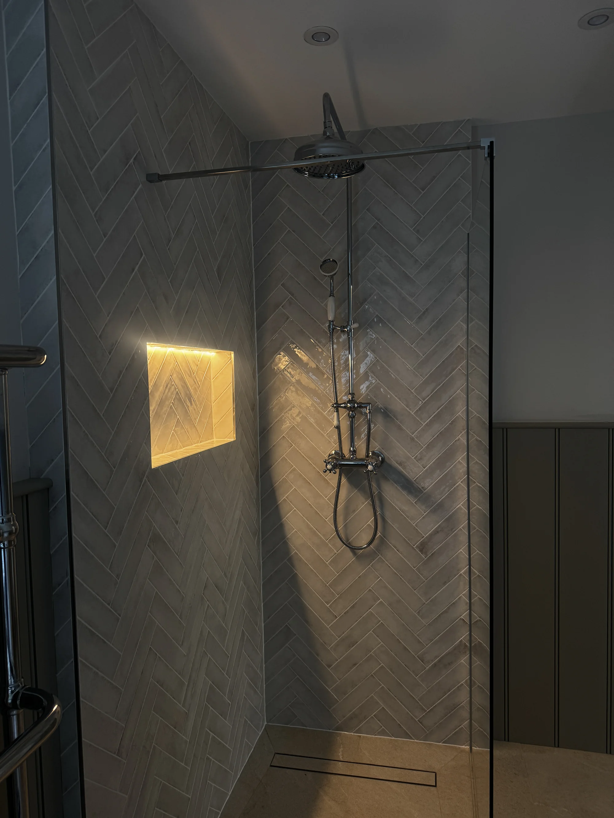 Exposed thermostatic shower against herringbone tiling, Baldock