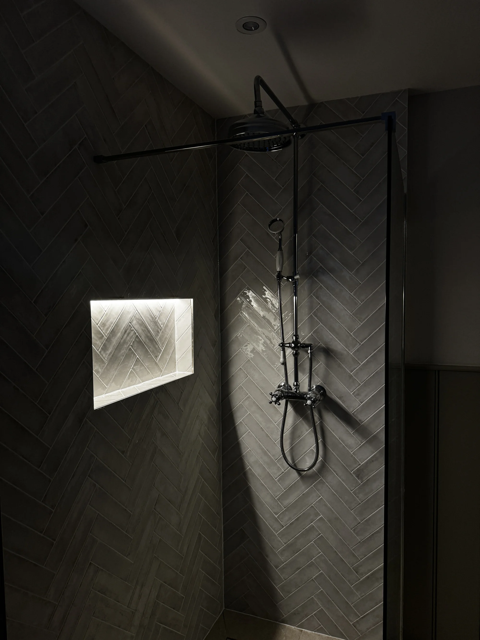 Lit shower niche set into the herringbone tiling, Baldock