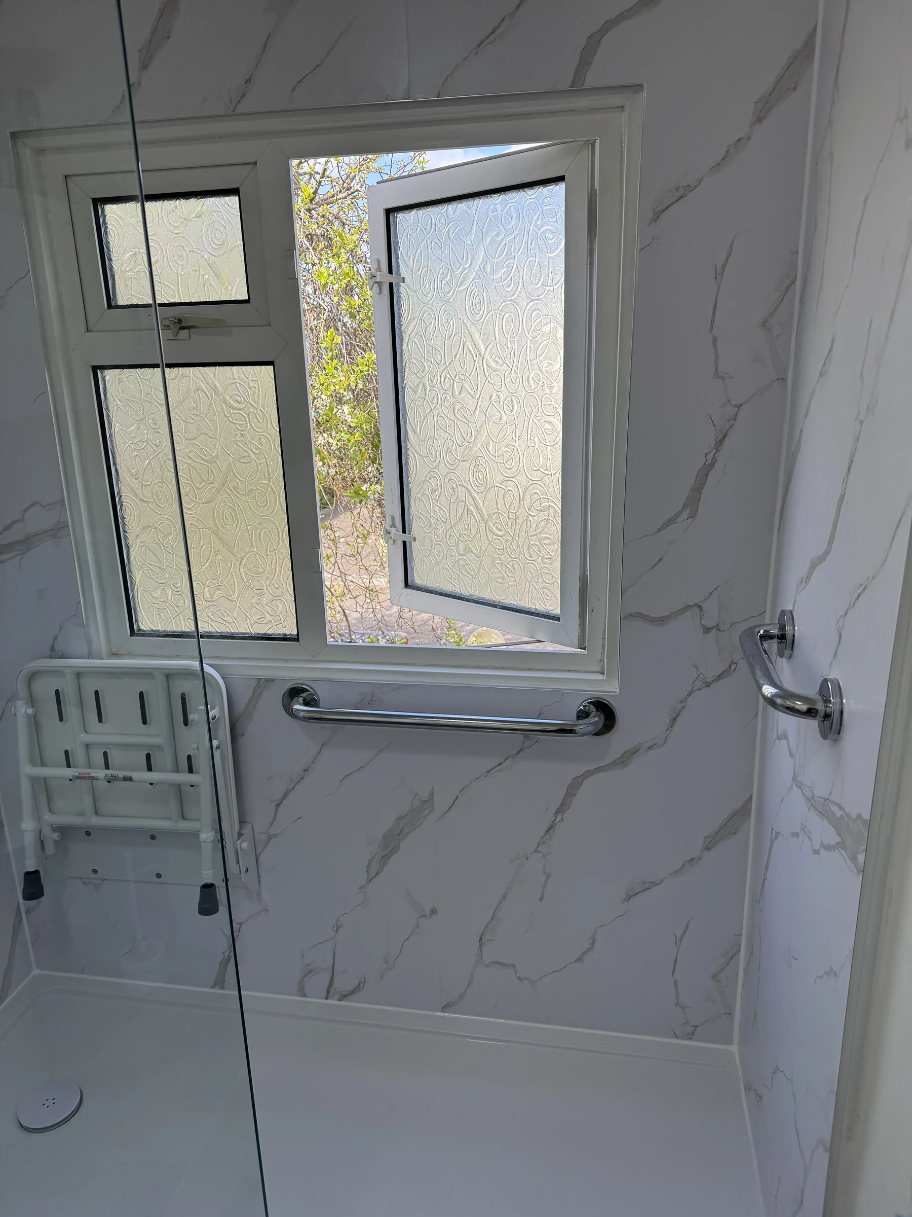 Fold-down shower seat and grab rail by the window, Hertfordshire