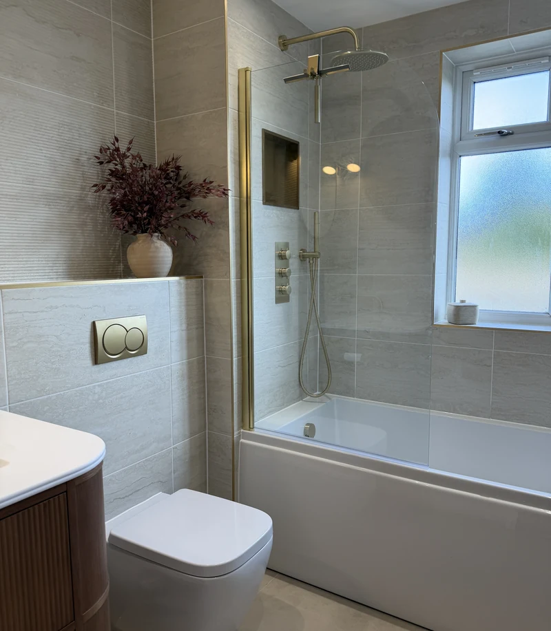 Bath with a brass shower over and obscured window, bathroom renovation Weston